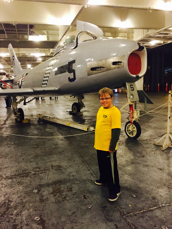 Young Craig standing next to a jet on an aircraft carrier